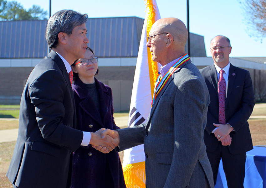 Republic of Korea Consul General Hyung Gil Kim, at left, presents Korean War veteran Antoine Otto with the Ambassador for Peace Medal for his service.