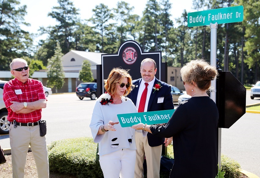 A road on East Mississippi Community College’s Scooba campus has been named after the late Buddy Faulkner, an EMCC alumnus. Here, Faulkner’s widow, Tina Faulkner, is presented with a duplicate road sign by EMCC Director of Alumni Affairs and Foundation Operations Gina Cotton.