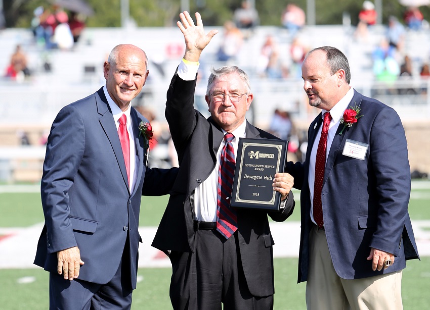 Kemper County native Dewayne Hull, at center, is presented with East Mississippi Community College’s 2018 Distinguished Service Award Oct. 13 during halftime of the college’s Homecoming game. Presenting the award are EMCC Interim President Dr. Randall Bradberry, at left, and EMCC Executive Director of College Advancement Marcus Wood, at right.