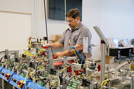 Mechatronics Technology instructor Ben Harris works on a miniature assembly line station used to train students in the new Mechatronics Technology program that will be offered at East Mississippi Community College’s Communiversity where registration is underway for classes that begin in August. 
