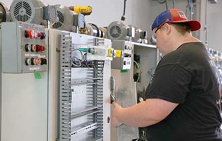 EMCC student Tyler Adair, who is in a work study program, helps set up a lab at the Communiversity, which will open for classes in the term that begins in August.