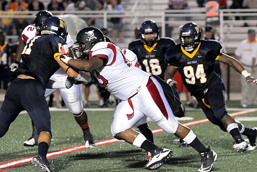 Former Lions football standout Derrick “DJ” Wilson, center, holds off a Gulf Coast Community College defender in this file photo from the 2011 season in which the Lions were undefeated and claimed a national championship. Wilson now owns a food catering business.