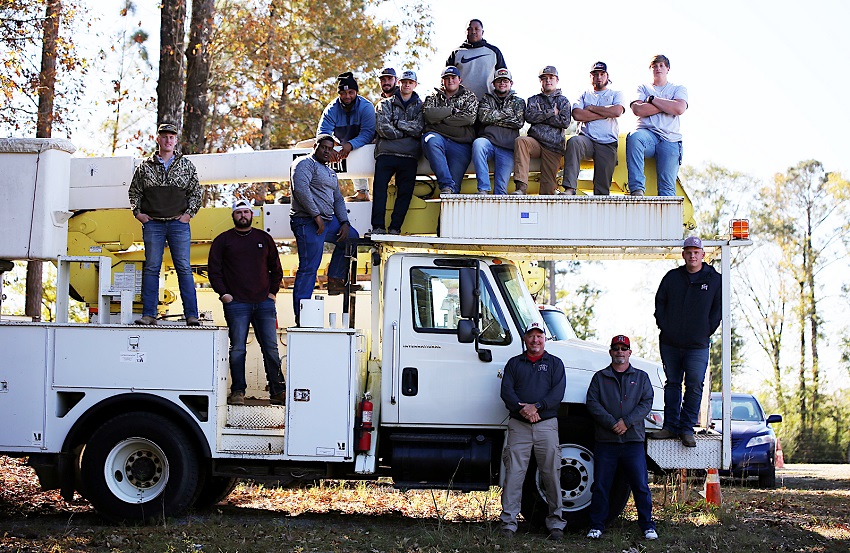 The Utility Lineworker Technology program is offered on East Mississippi Community College’s Scooba campus. Here, students take a break from their studies for a photo. Standing on the ground, from left, are program instructors Chuck Cotton and Kevin Rushing. 