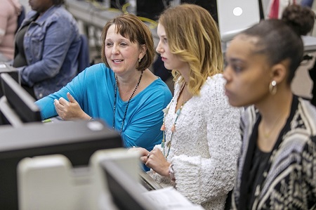 East Mississippi Community College Business Office Technology instructor Trina Dendy, at left, works with students in one of her classes in this file photo. Dendy and other EMCC instructors have since transitioned to online instruction in response to the coronavirus.