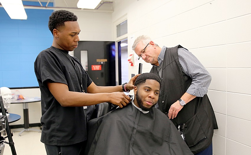 East Mississippi Community College Barbering student Tedarrious Barr, at left, cuts Columbus resident Jayvious Sparks’ hair under the watchful eye of EMCC Director of Barbering and Cosmetology David Long. 