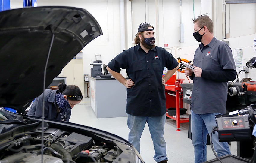 East Mississippi Community College Automotive Technology/Diesel Mechanics Department Head Dale Henry, at right, speaks with student Thomas Murray while Alexis Phillips, at left, works on a car in an Automotive Technology class on the college’s Golden Triangle campus.