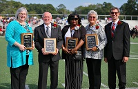 Four East Mississippi Community College alumni were honored Oct. 9 during the halftime of the college’s Homecoming football game and were presented plaques by EMCC President Dr. Scott Alsobrooks, far right. The honorees are, from left, Dr. Emily Warren, 2020 Alumna of the Year; Charlie Studdard, 2020 Distinguished Service Award; Teresa Hughes, 2021 Distinguished Service Award, and Cheryl Sparkman, 2021 Alumna of the Year.