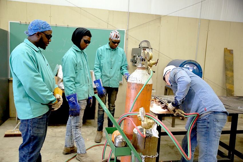 From left, Plum Creek Environmental employees Arthur Woodlaw, Kurtis Bradford and Brandon Gandy look on as East Mississippi Community College welding instructor Levi Linton demonstrates a welding technique. EMCC and Plum Creek have partnered to offer the course. 
