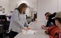 East Mississippi Community College Business and Marketing Management Technology program instructor Shannon Miller, at left, goes over an assignment with students in one of her classes.