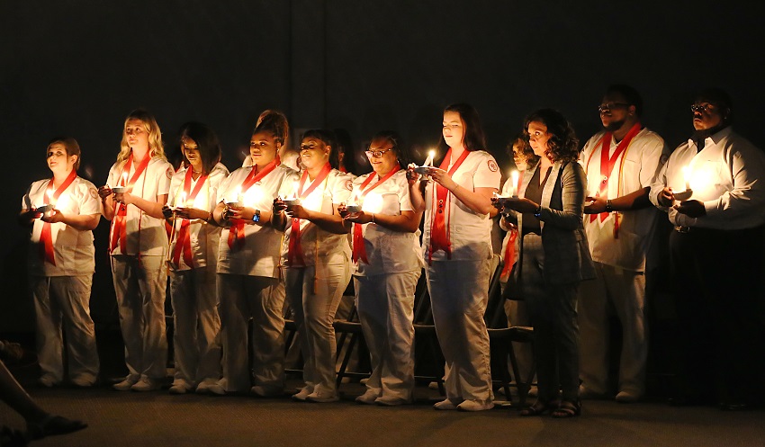 East Mississippi Community College Practical Nursing graduates take part in a ceremonial lighting of the lamps during a July 29 commencement ceremony at the college’s Golden Triangle campus. 