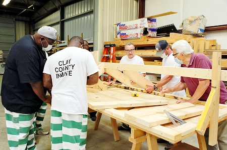 EMCC’s Workforce and Community Services division offers many programs to help residents in the college’s district, including these inmates at the Clay County Detention Center, who completed a Construction Skills class. The inmates are trustees with nonviolent offenses. Here, program instructor Johnny Duren, at right, looks on as the inmates frame a roof during class. 