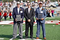 EMCC President Dr. Scott Alsobrooks, center, presents Tommy Tomlinson, at left, with the 2023 Alumnus of the Year Award, and Pat Granger, at right, with the 2023 Distinguished Service Award during halftime of the college’s Oct. 21 Homecoming football game. 