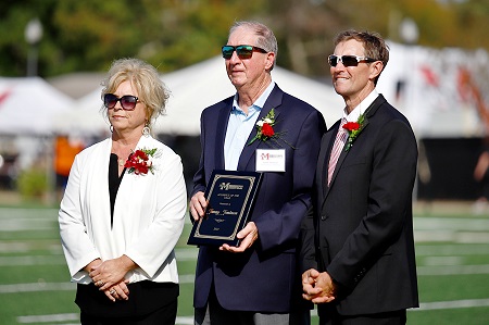 Starkville native Tommy Tomlinson, center, is EMCC’s 2023 Alumnus of the Year. He is presented his award during the college’s Oct. 21 Homecoming game by EMCC President Scott Alsobrooks, at right, and Executive Director of Alumni Affairs and Foundation Operations Gina Cotton. 