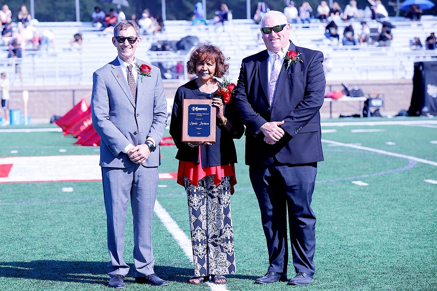 Linda Jackson, at center, is EMCC’s 2025 Distinguished Service Award recipient. She was recognized here during halftime of EMCC’s Oct. 11 Homecoming football game by EMCC President Dr. Scott Alsobrooks, at left, and Dean of Scooba Campus/College Advancement Tony Montgomery.
